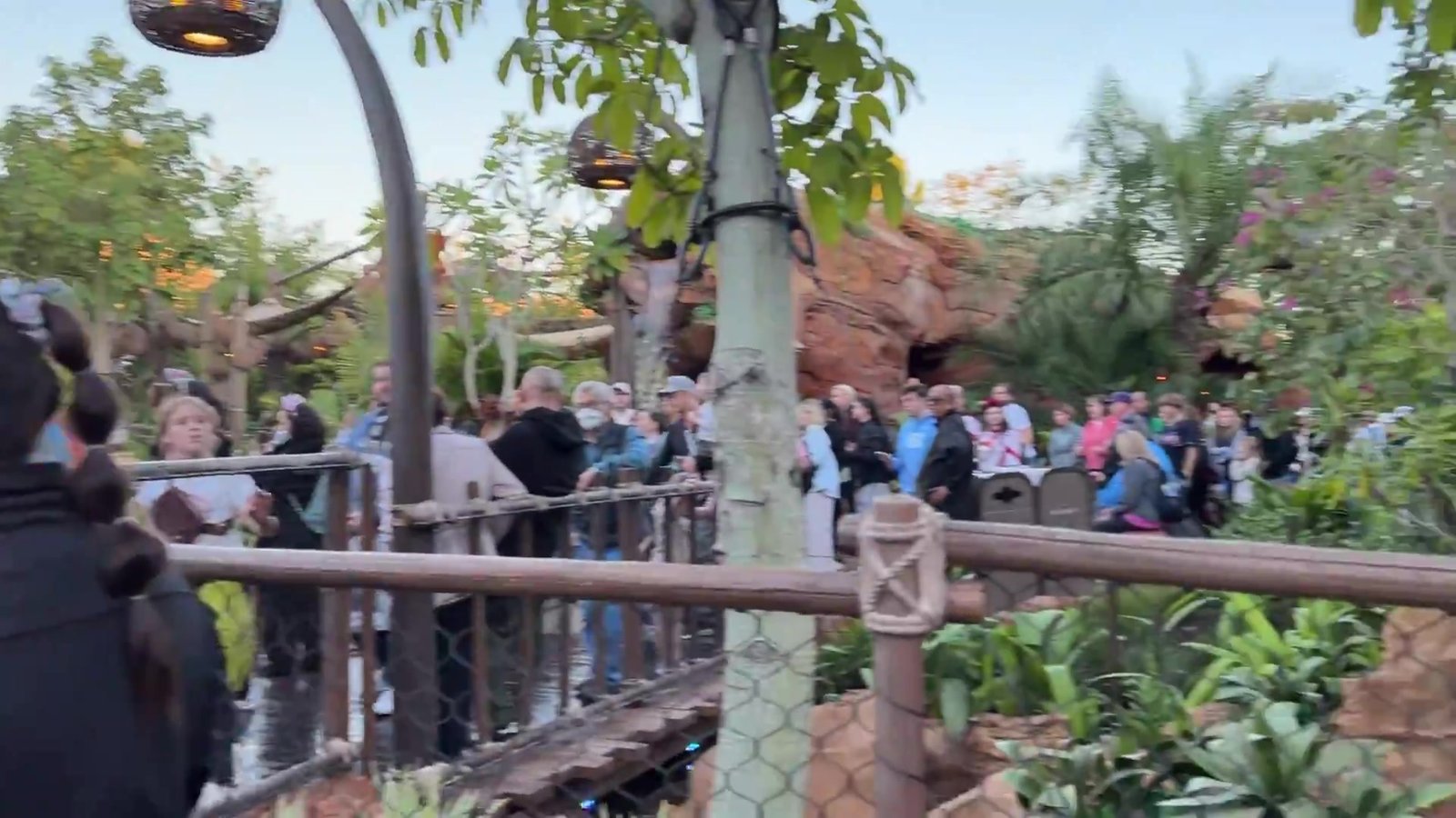 Visitantes percorrendo a passarela de madeira entre pedras e plantas na Journey of Water do Epcot