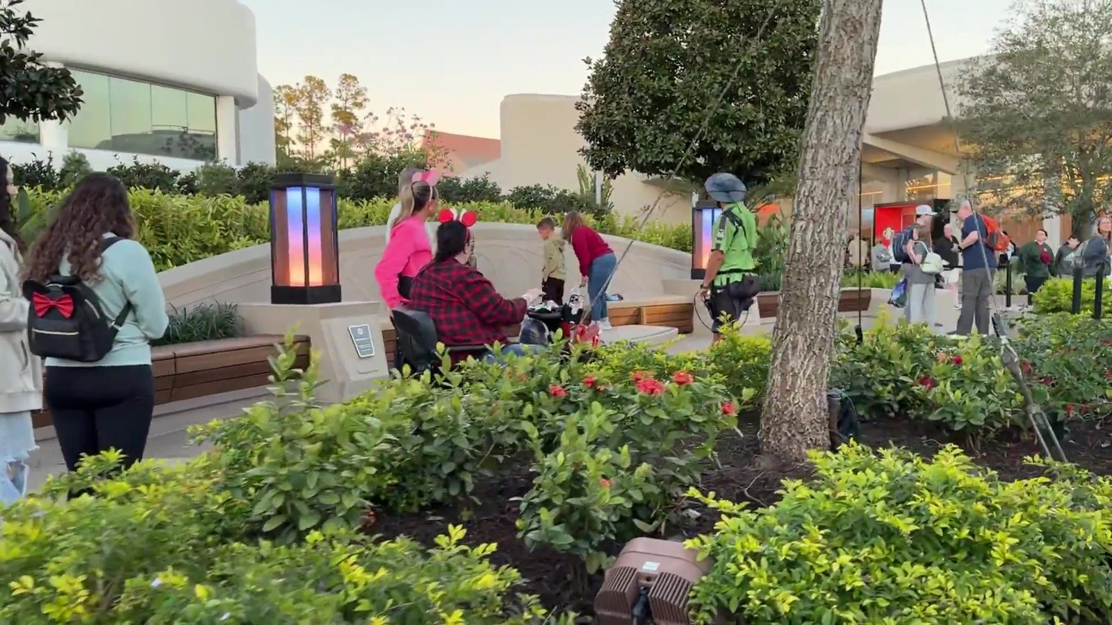 Área de descanso do Epcot com colunas de luz coloridas, bancos e visitantes sentados