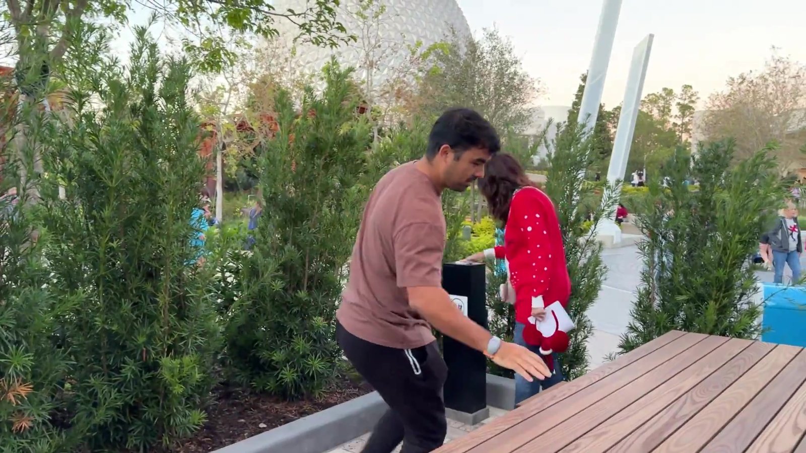 Gustavo debruçado numa das mesas de madeira novas do Epcot testando o ponto de carregamento