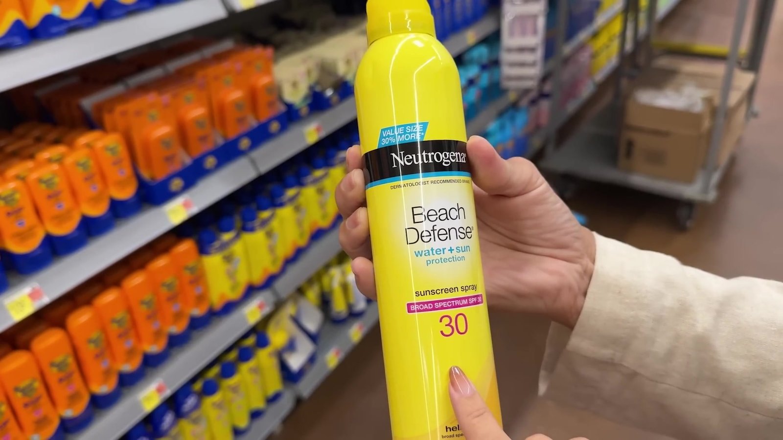 Protetor solar Neutrogena Beach Defense em spray na mão, no corredor do Walmart de Orlando