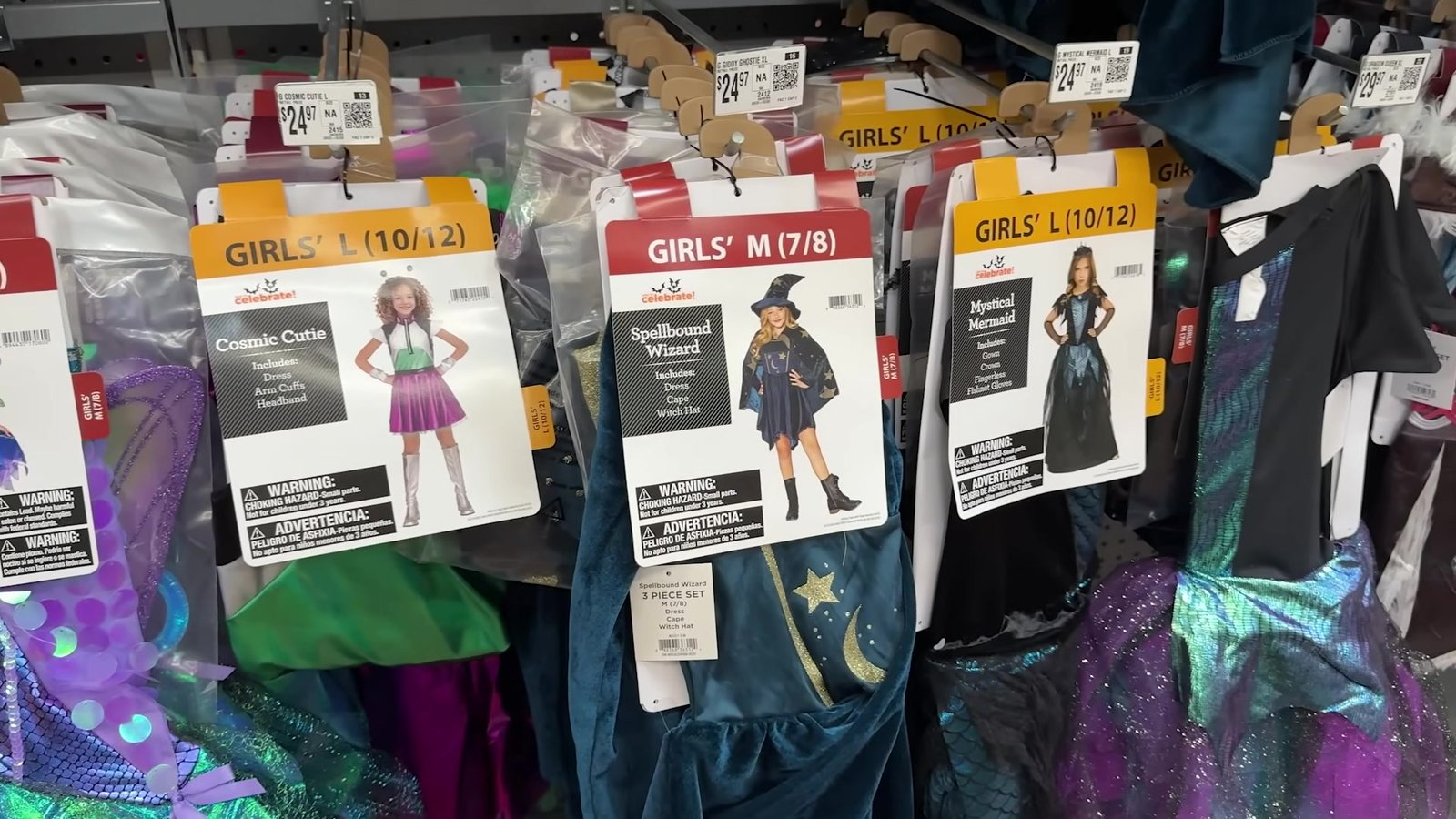 Fantasias infantis femininas penduradas no corredor de Halloween do Walmart, com etiqueta de US$ 24,98