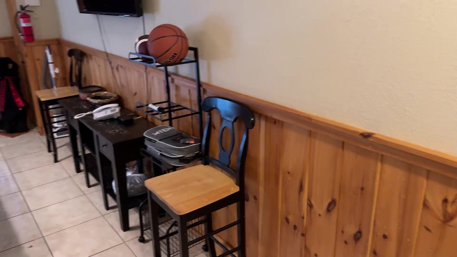 Área de jogos da cabana com bancos altos, bola de basquete e paredes de madeira