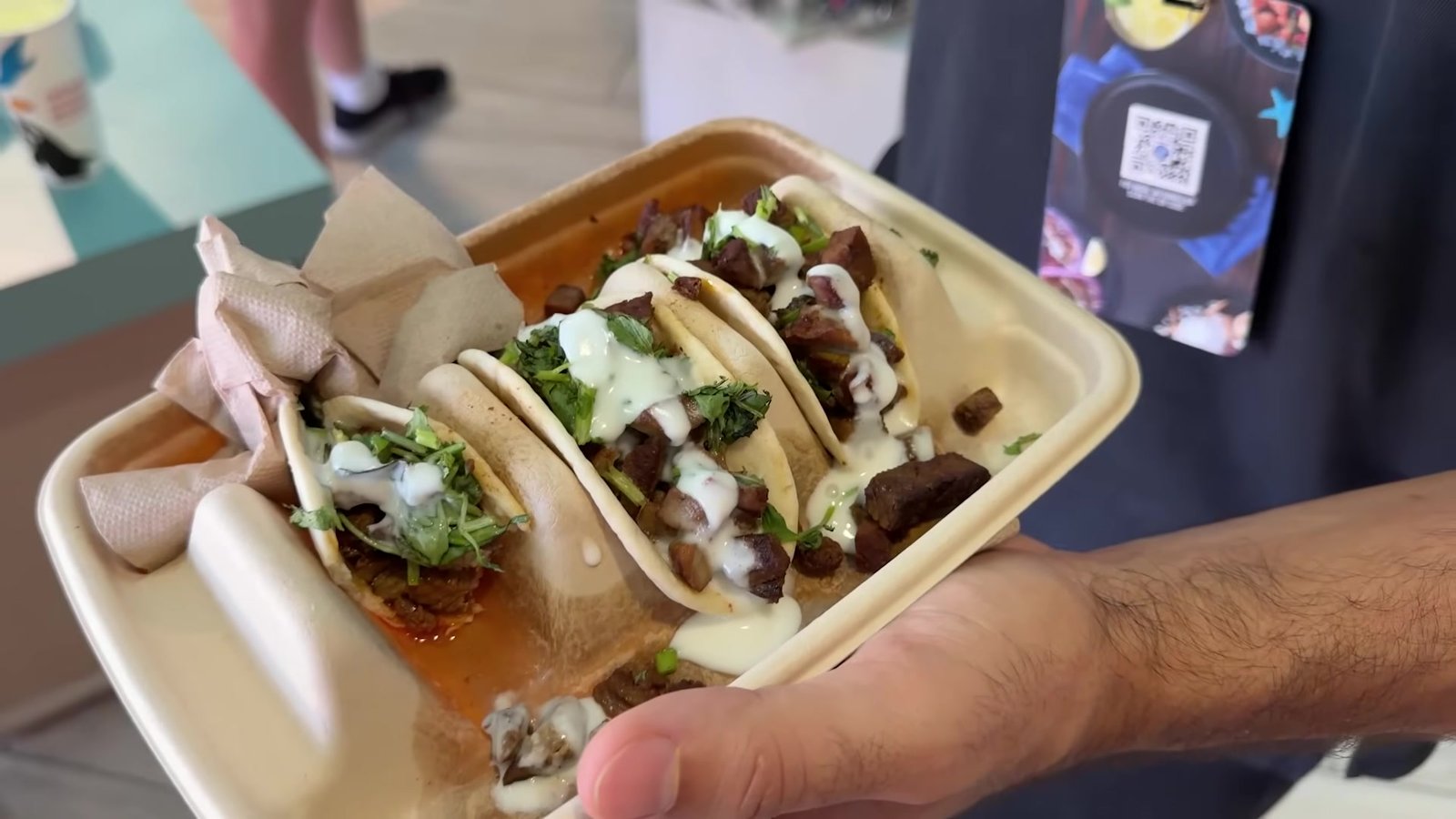 Três tacos de carne com coentro e molho branco na bandeja, do Panini Shore Café