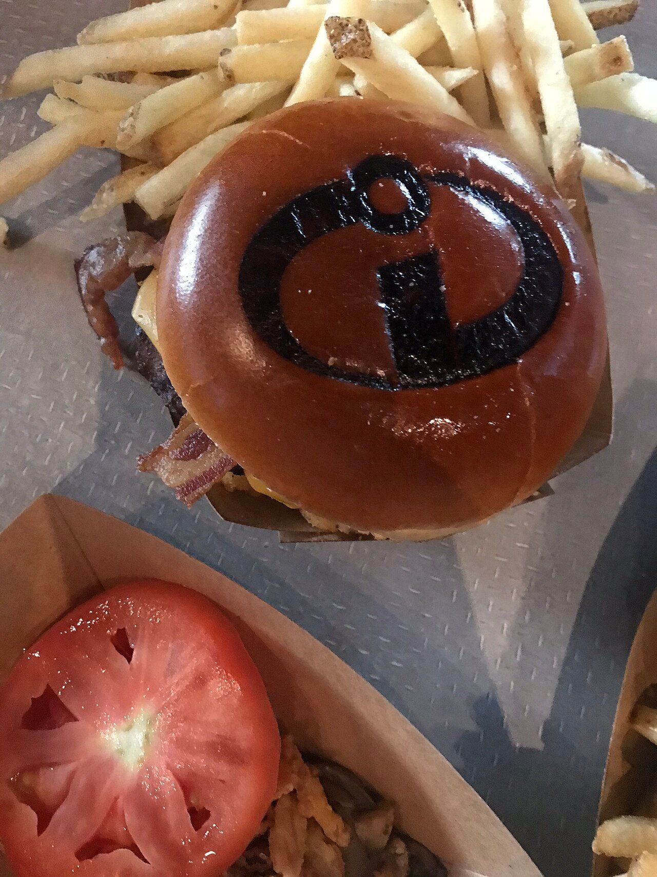 Hambúrguer temático dos Incríveis com batata frita, típico de refeição quick da Disney