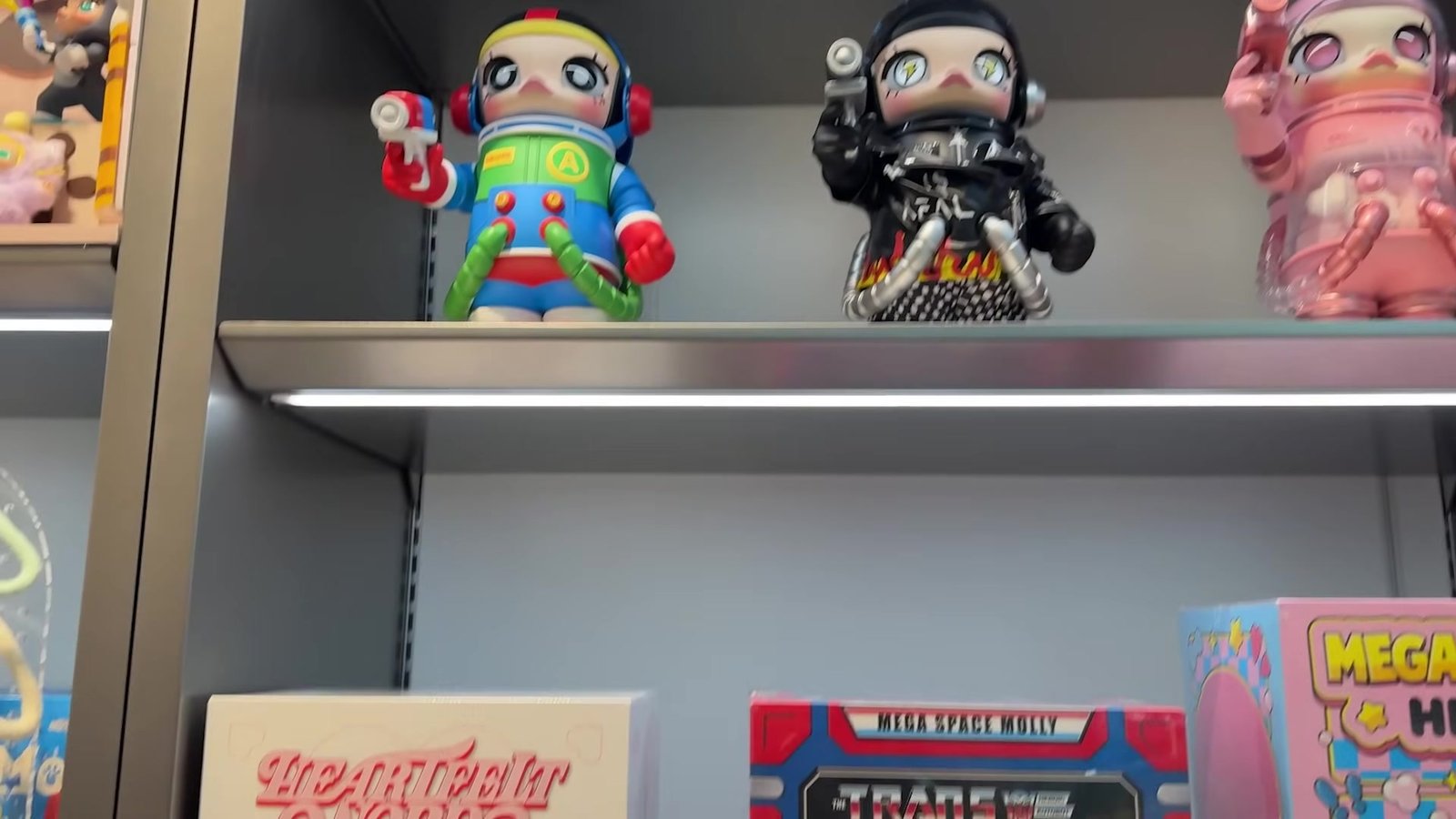 Bonecos grandes da Molly em cima de caixas da Mega Space Molly na prateleira da Pop Mart