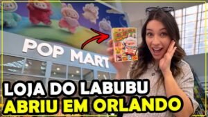 Gabi segurando uma caixinha de colecionável em frente ao letreiro da Pop Mart, a loja do Labubu em Orlando