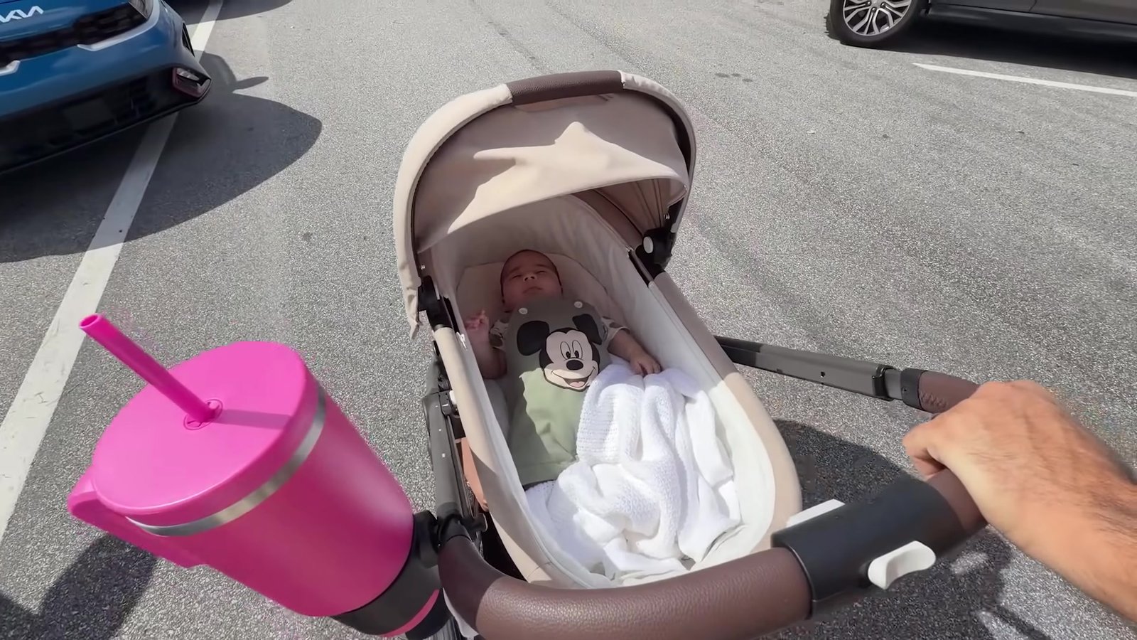 Bebê Lian deitado no moisés do carrinho no estacionamento do Magic Kingdom