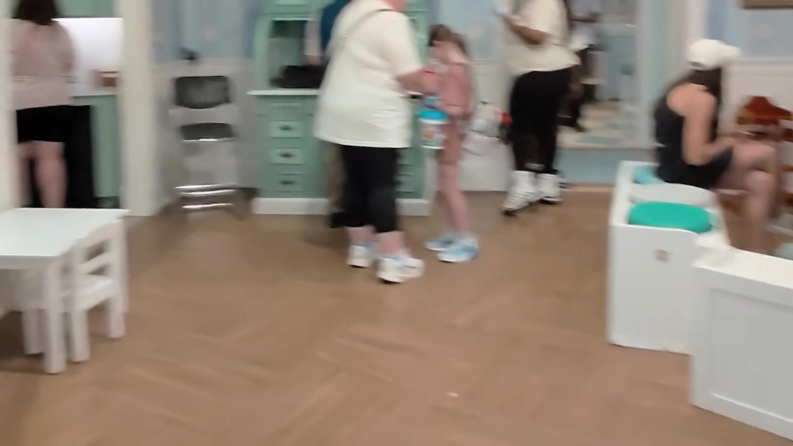 Área de entrada do Baby Care Center do Magic Kingdom, com famílias e mesinhas infantis