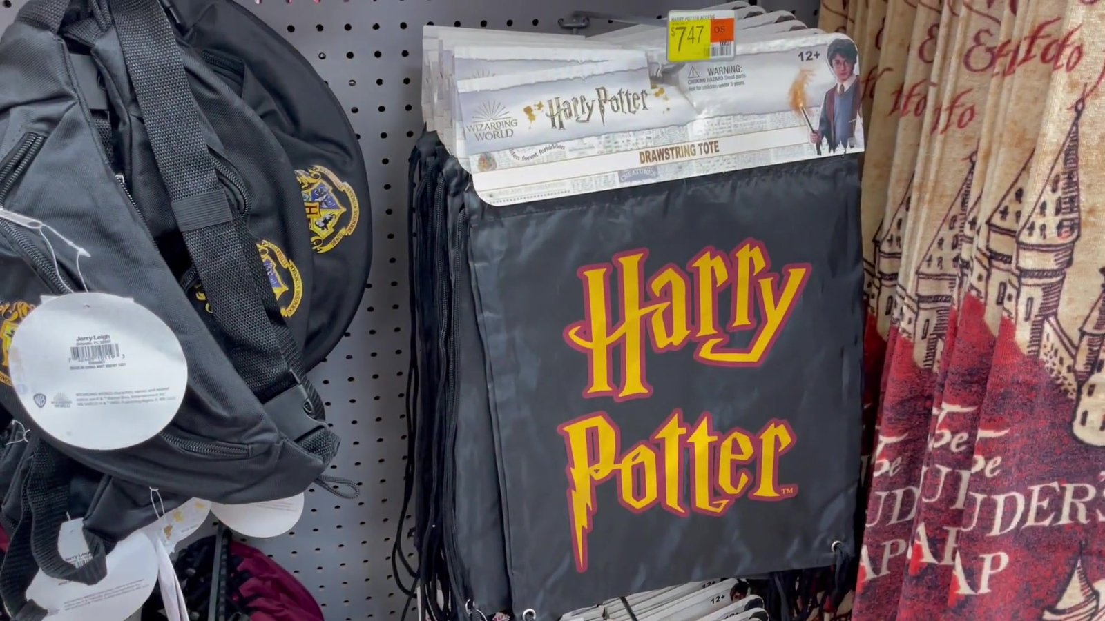 Mochila saco do Harry Potter e toalha do Mapa do Maroto penduradas no corredor do Walmart