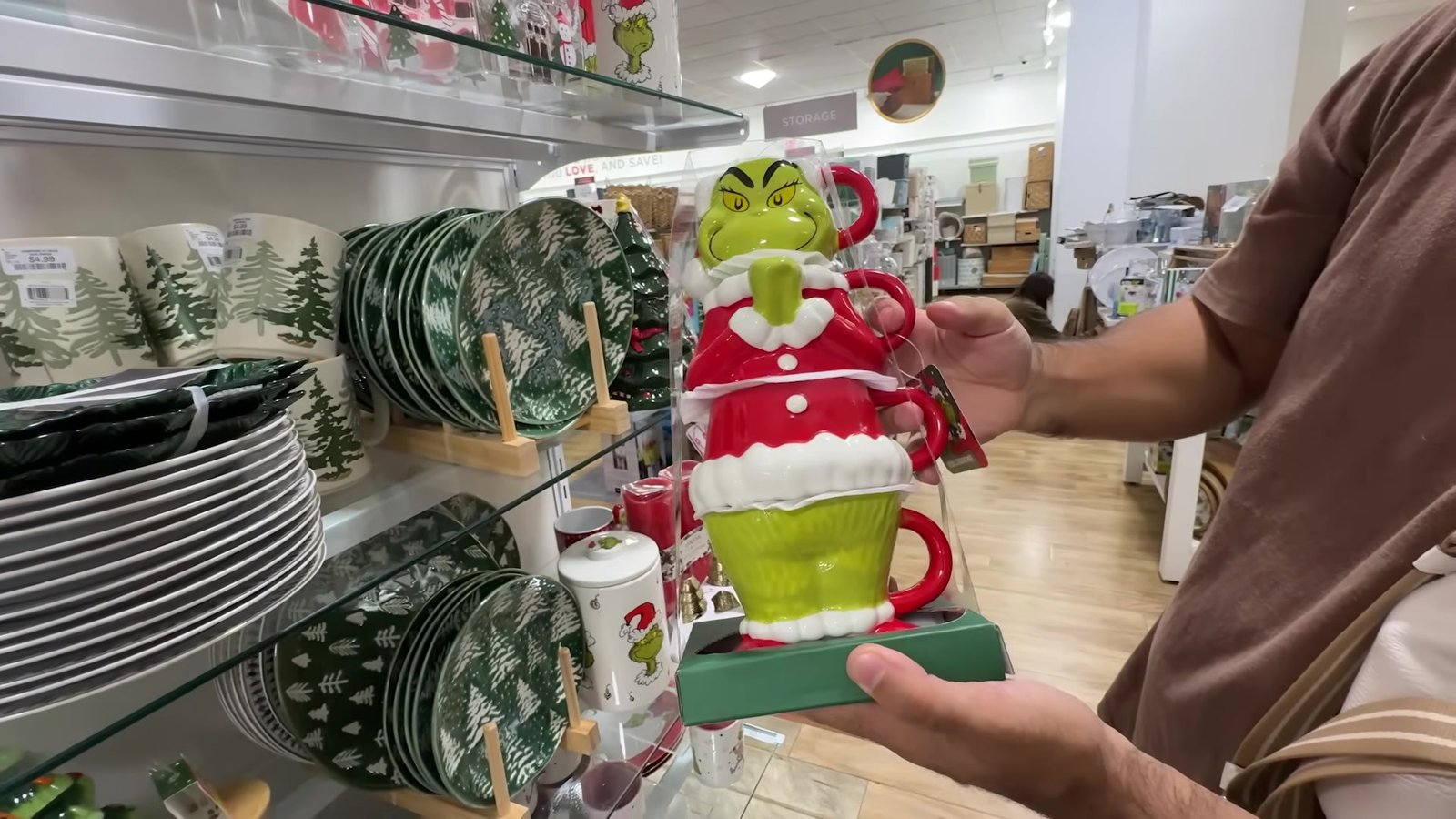 Kit de canecas empilhadas do Grinch, com a cabeça dele como tampa, na mão na HomeGoods