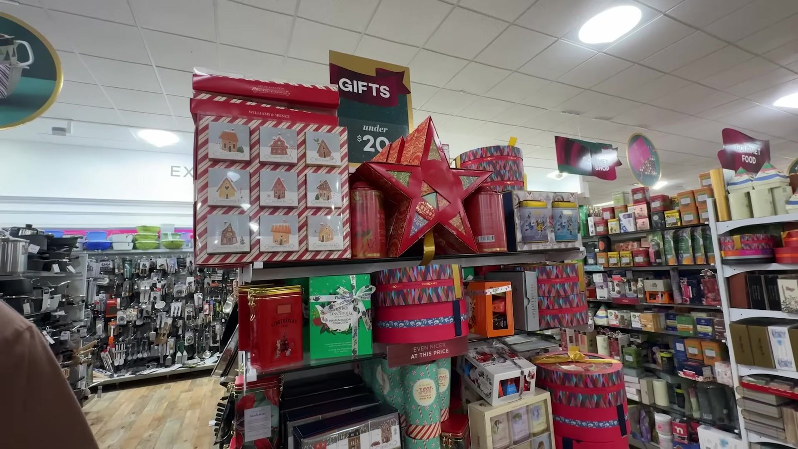 Ilha de presentes abaixo de US$ 20 com estrela vermelha gigante e caixas de Natal na HomeGoods