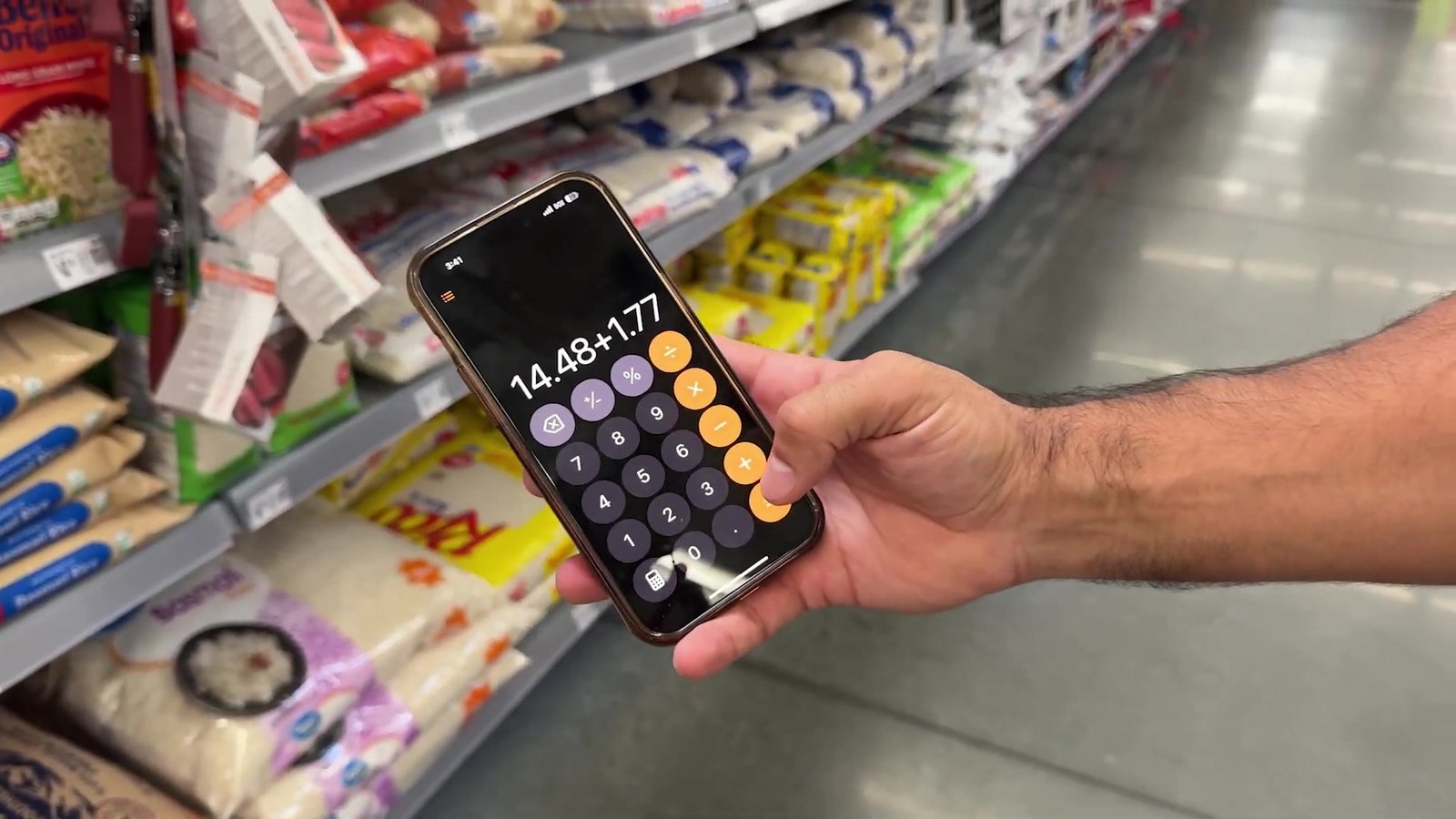 Calculadora somando os itens em frente aos pacotes de arroz no Walmart