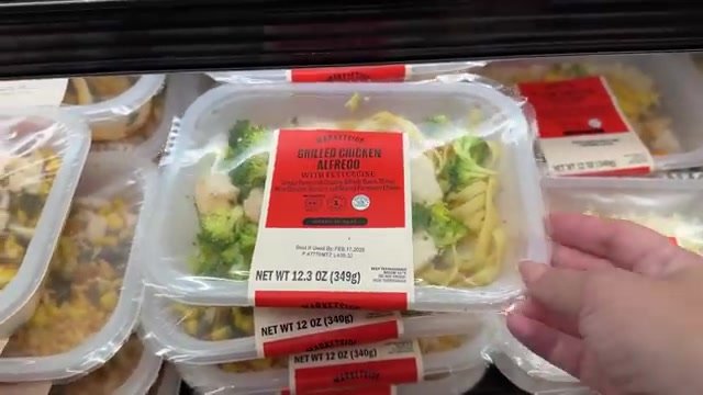 Bandejas de Fettuccine Alfredo com frango e brócolis na geladeira de pratos prontos do Walmart