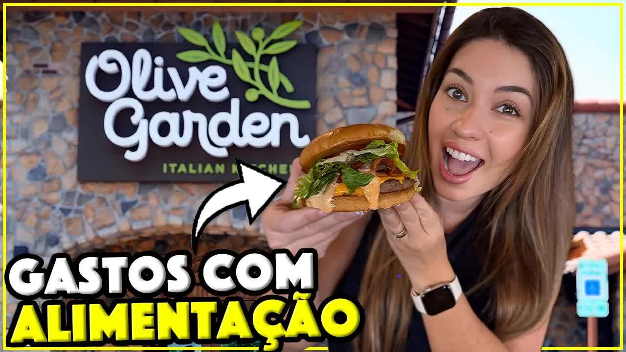 Gabi segurando um hambúrguer em frente ao Olive Garden, sobre os gastos com alimentação em Orlando