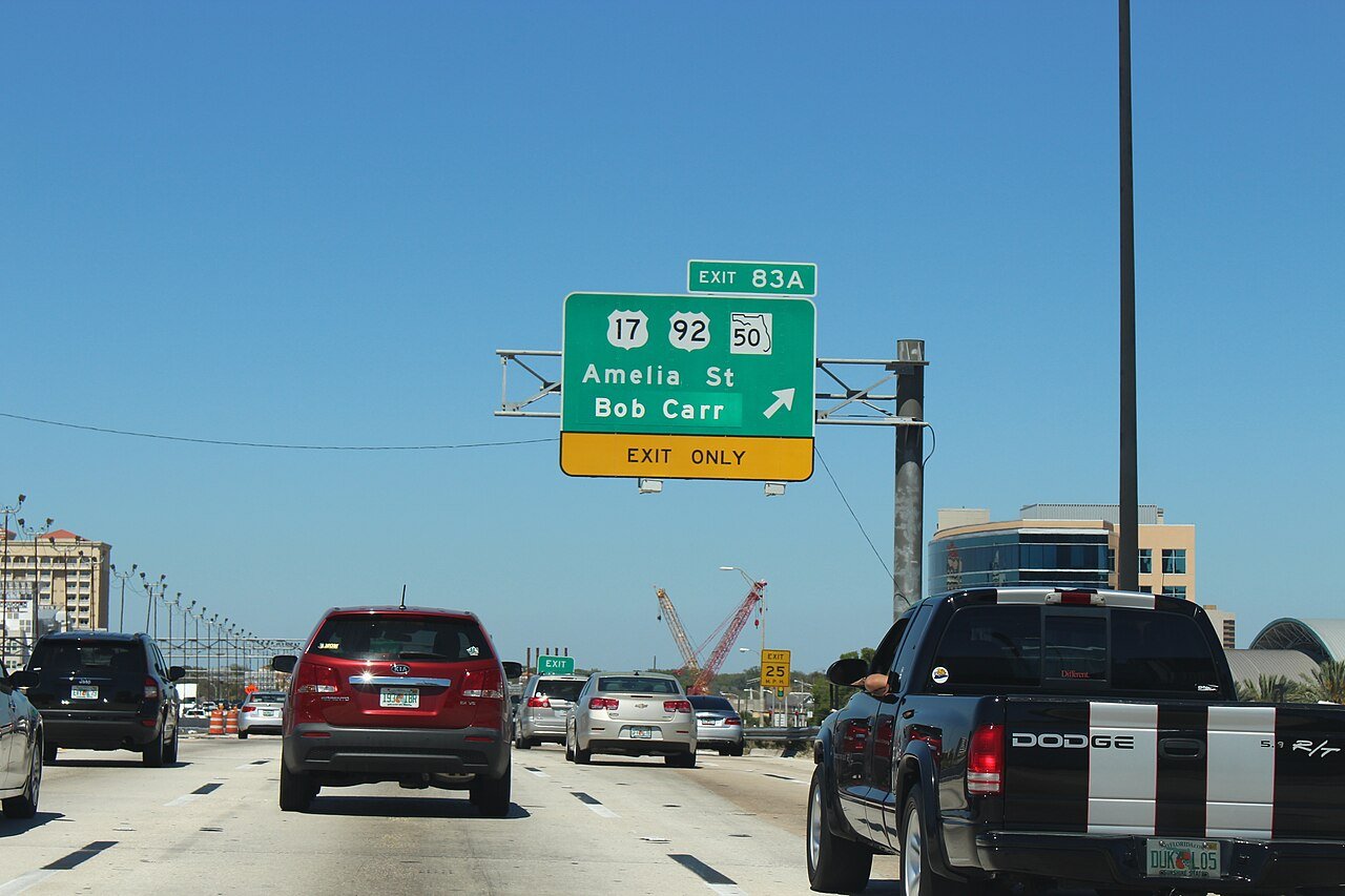 Trânsito na rodovia I-4 em Orlando com placa de saída