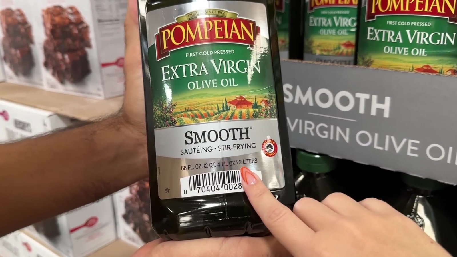 Garrafa de azeite extra virgem Pompeian de 2 litros na mão, no corredor de azeites do Sam's Club
