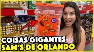 Gabi segurando um balde de Reese's com 375 unidades no corredor de doces do Sam's Club de Orlando