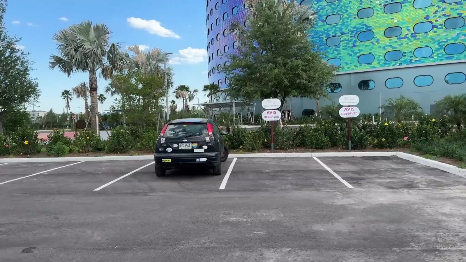 Estacionamento do Terra Luna com a fachada colorida do hotel ao fundo