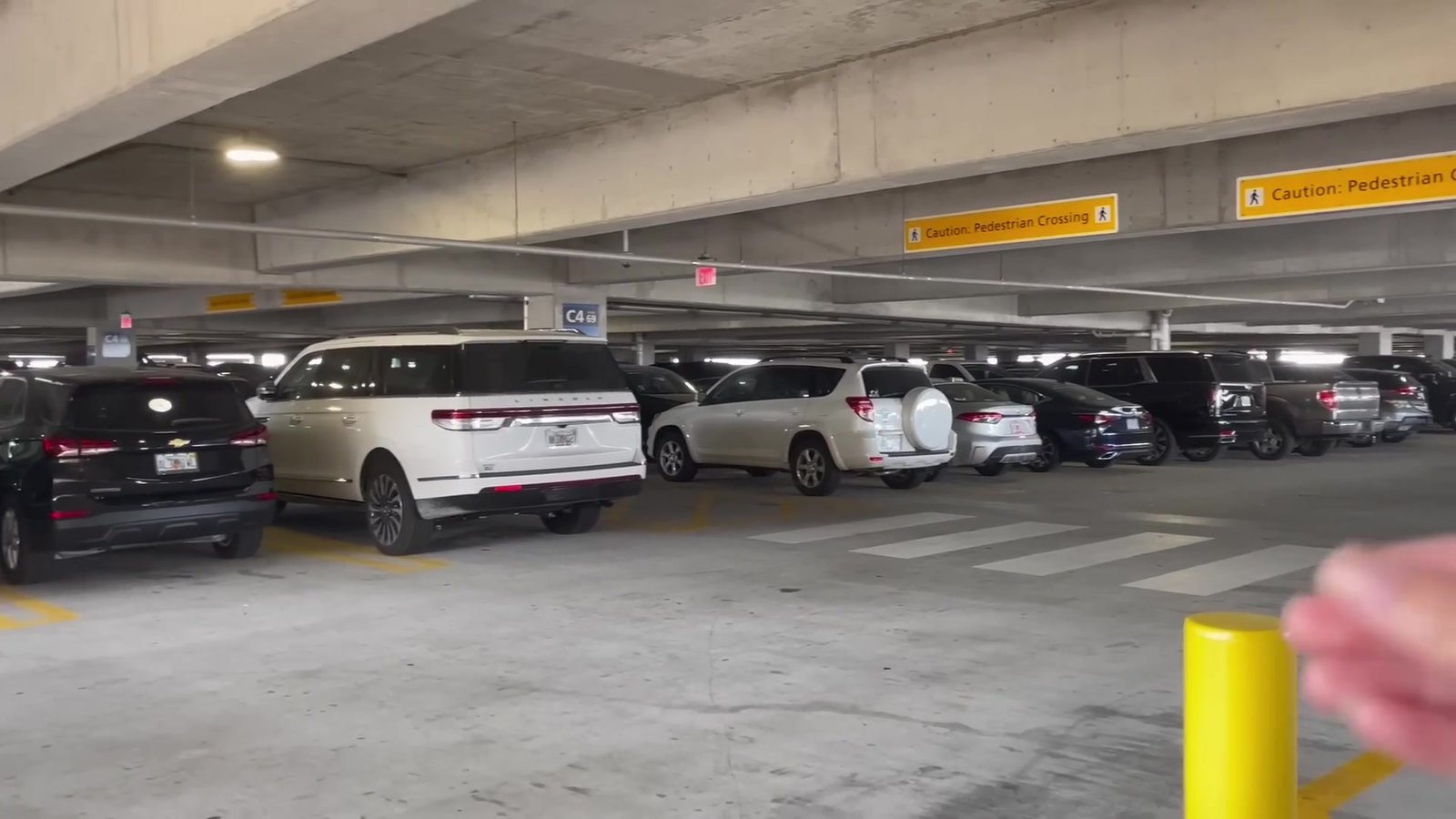 Estacionamento coberto do Terminal C do Aeroporto de Orlando com carros estacionados