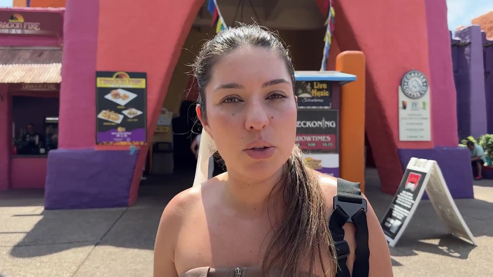 Gabi em frente ao Dragon Fire Grill, o restaurante de fachada rosa do Busch Gardens