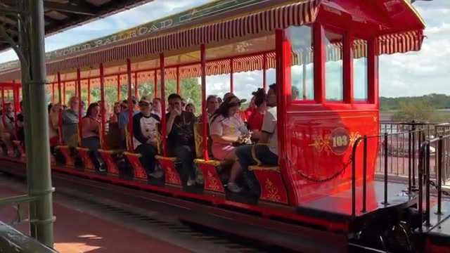 Vagão vermelho número 103 do trem do Magic Kingdom lotado de passageiros na estação