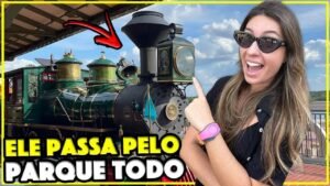 Gabi apontando para a locomotiva verde do trem do Magic Kingdom na estação da Main Street