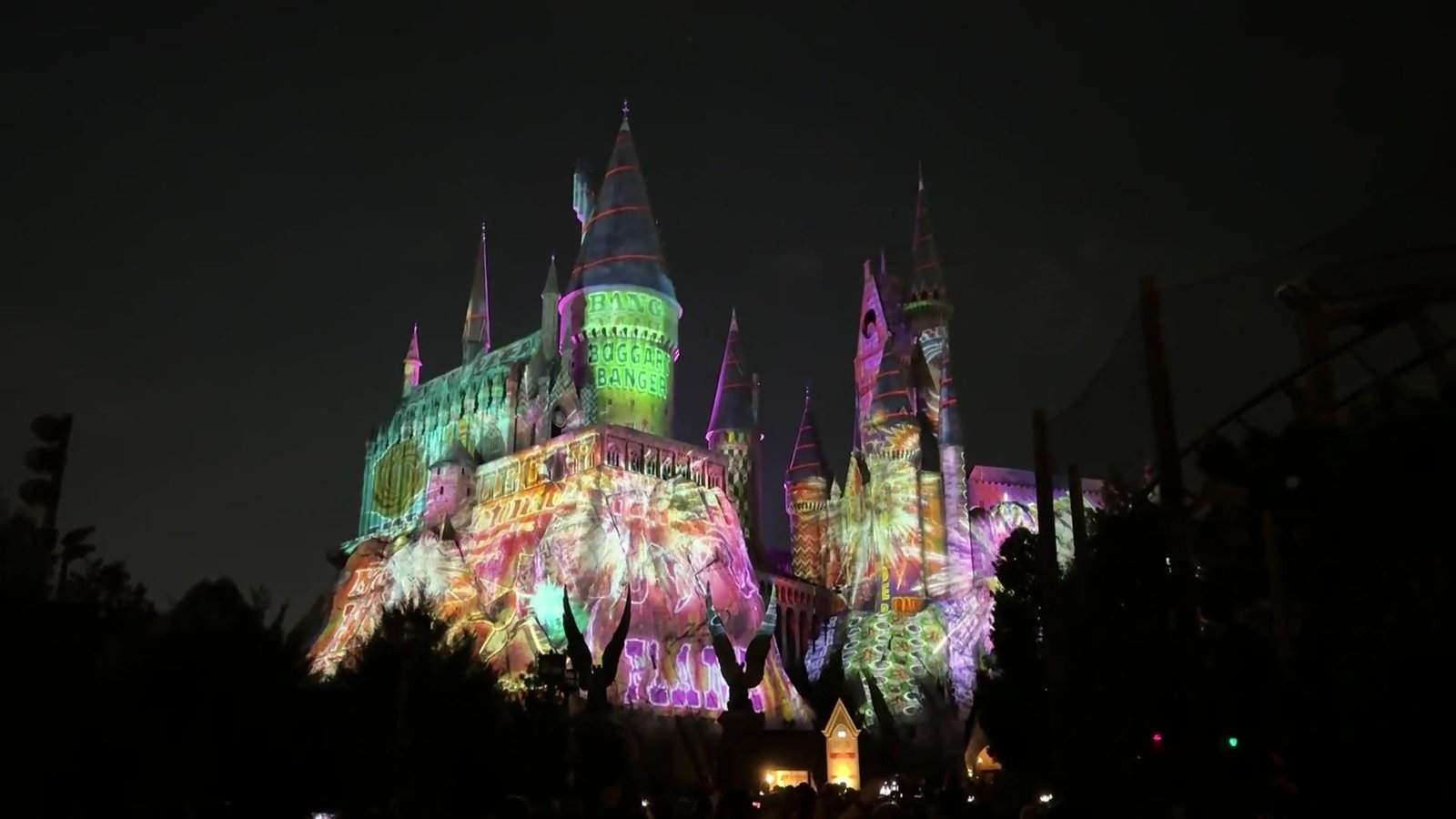 Castelo de Hogwarts iluminado com projeções coloridas no show de Natal da Universal