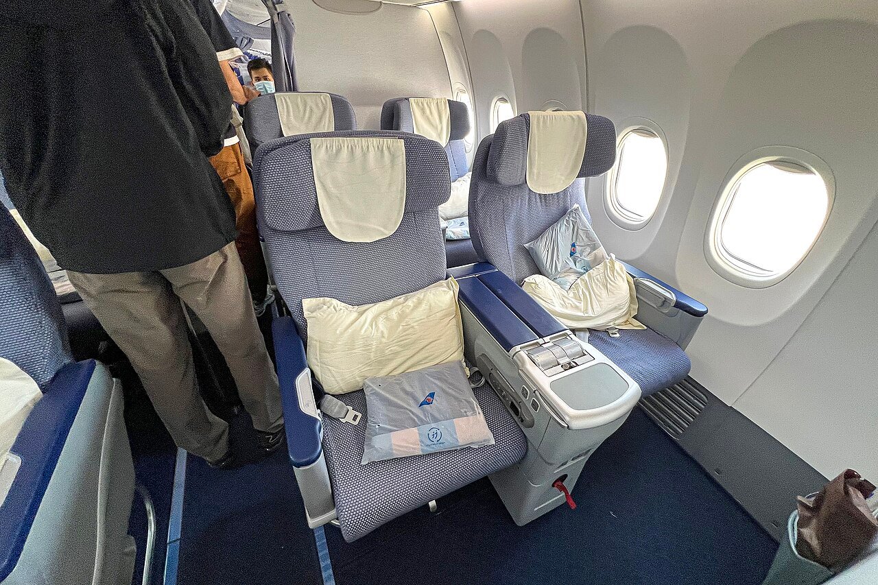 Cabine de classe executiva de um avião, com poltronas reclináveis