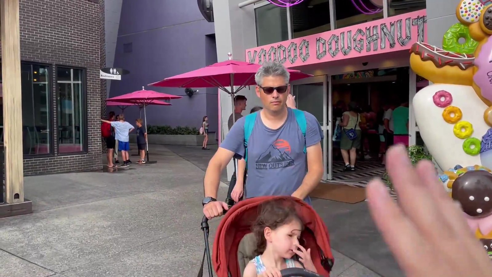 Fachada rosa da Voodoo Doughnut no Universal CityWalk, com esculturas de donuts gigantes e guarda-sóis