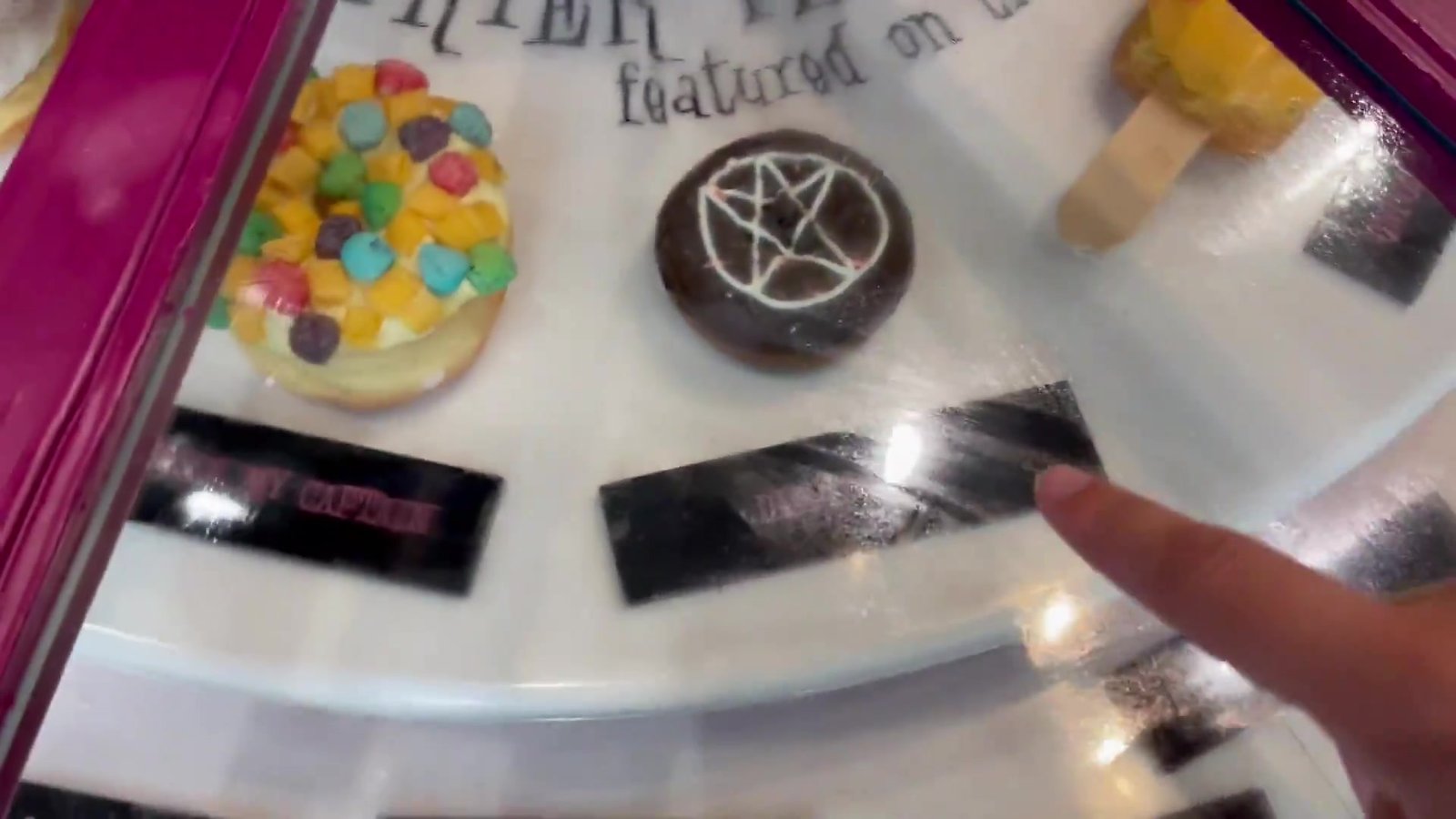 Vitrine giratória da Voodoo Doughnut com donut de Froot Loops e donut com pentagrama de chocolate