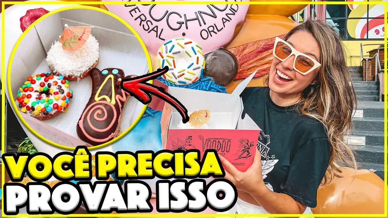 Gabi segurando a caixa rosa da Voodoo Doughnut com donuts coloridos e o Voodoo Doll em destaque