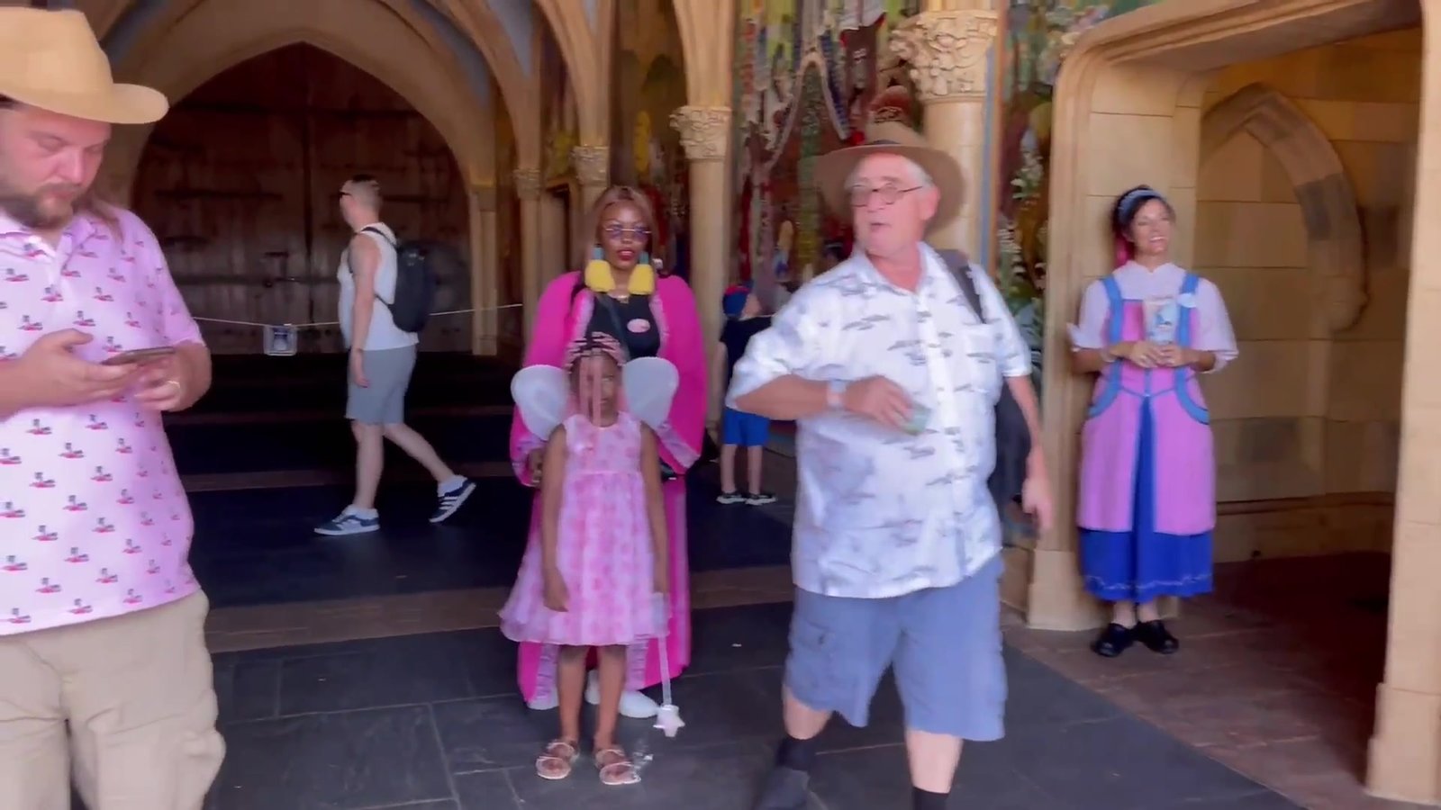 Corredor que atravessa o Castelo da Cinderela, com visitantes e uma cast member