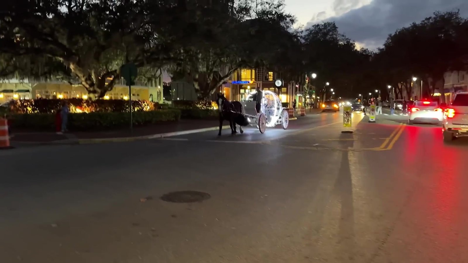 Carruagem branca puxada a cavalo iluminada na rua principal de Celebration